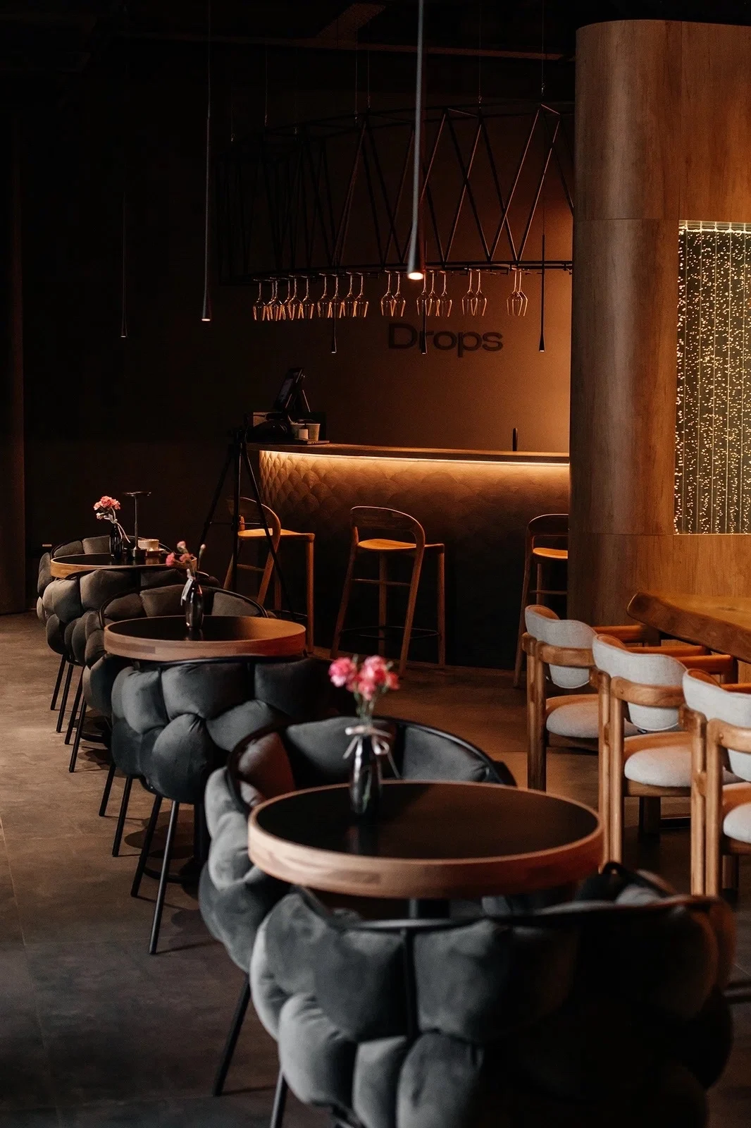 Drops Izakaya & Wine Bar — Общий стол под декоративным подвесом, работающим как главный световой акцент.